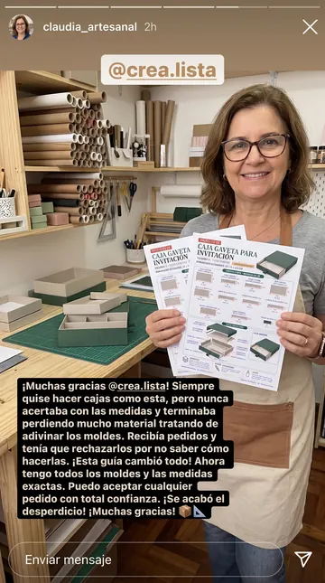 Artesana mostrando las láminas de proyecto impresas en su taller