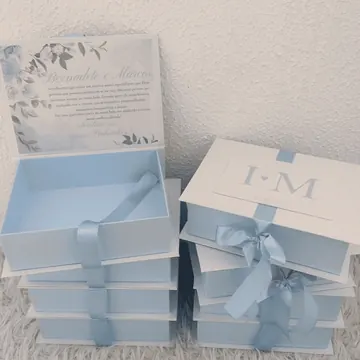Cajas azul y blanca para invitación de boda, apiladas con lazo de satén